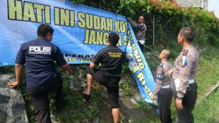 Anggota Polres Bogor memasang spanduk himbauan keselamatan berkendara di Jl. Raya Puncak, Rabu 6/6 (dok. KM)