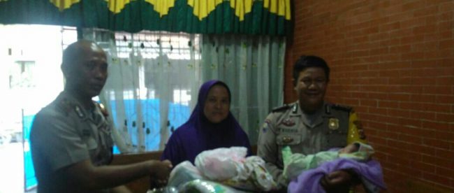 Petugas daei Polsek Gunungputri, Kabupaten Bogor, menyerahkan bayi yang ditinggal orangtuanya kepada Bidan Desa Bojong Kulur, Sabtu 28/7/2018 (dok. KM)