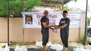 Ketua DPD PKS Kota Langsa memberikan daging qurban kepada salah satu masyarakat di Gampong Paya Bujok Tunong. (Dok.KM)