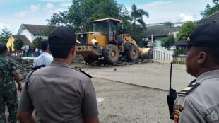 Polisi memantau proses pembersihan bebatuan yang sengaja diturunkan di tengah jalan dekat kantor Kecamatan Gunung Sindur, Rabu 2/1/2019 (dok. KM)