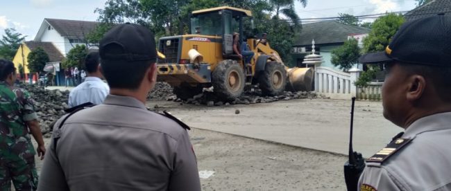 Polisi memantau proses pembersihan bebatuan yang sengaja diturunkan di tengah jalan dekat kantor Kecamatan Gunung Sindur, Rabu 2/1/2019 (dok. KM)