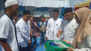 Wakil Bupati Aceh Tamiang T. Insyafuddin menyematkan tanda peserta kepada para peserta MTQ di Lapas Kelas II B Kuala Simpang, Jumat 29/3/2019 (dok. Muddin/KM)