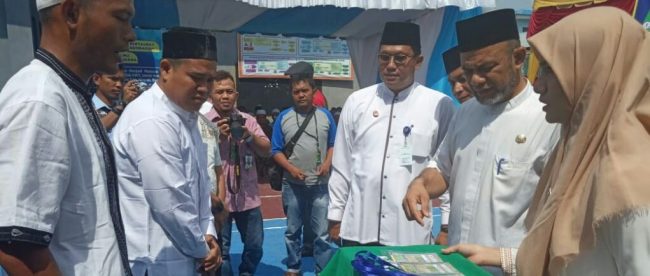 Wakil Bupati Aceh Tamiang T. Insyafuddin menyematkan tanda peserta kepada para peserta MTQ di Lapas Kelas II B Kuala Simpang, Jumat 29/3/2019 (dok. Muddin/KM)