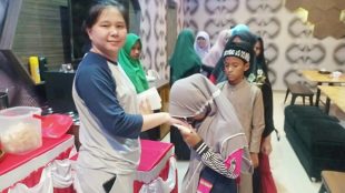 Sulina, Manajer Planet Eleven Sport & Cafe menyatuni anak yatim dalam kegiatan yang dilakukan oleh Planet Eleven Sport & Cafe (dok. KM/ Syahroel)