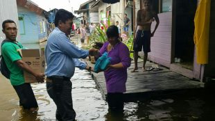 Anggota DPRD Kota Samarinda, Joni Ginting, menyerahkan bantuan kepada korban banjir di Samarinda, Kamis 13/6/2019 (dok. KM)