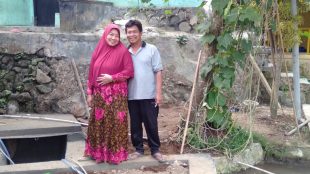Usep Burhanudin beserta istrinya, Nur Hamidah di depan bak air yang menyalurkan air bersih kepada 32 KK di Kampung Nangka Berit Jogjogan, Desa Cidahu, Kecamatan Cidahu, Kabupaten Sukabumi (dok. KM)