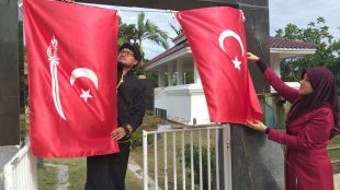 Warga sedang memasang bendera Alam Peudeung di depan Kompleks Makam Desa Bitai, Kamis 28/8/2019 (dok. KM)