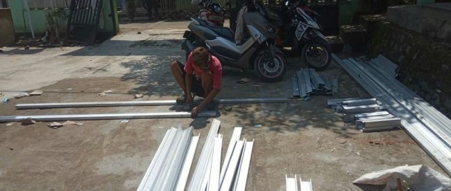 Terlihat hanya seorang pekerja yang sedang merangkai baja ringan dengan mengoplos baja ringan bekas untuk rangka atap di SDN Purasari 02, Leuwiliang, Kabupaten Bogor (dok. KM)