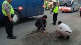 Polisi menutupi lubang di Jalan Yos Sudarso, Gombong, Kebumen, dengan adukan semen (dok. KM)