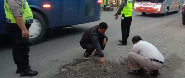 Polisi menutupi lubang di Jalan Yos Sudarso, Gombong, Kebumen, dengan adukan semen (dok. KM)