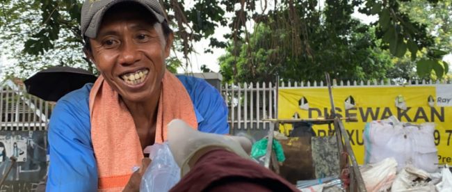 Seorang pemulung menerima sumbangan nasi bungkus dari SMAKBO, Selasa 31/3/2020 (dok. KM)