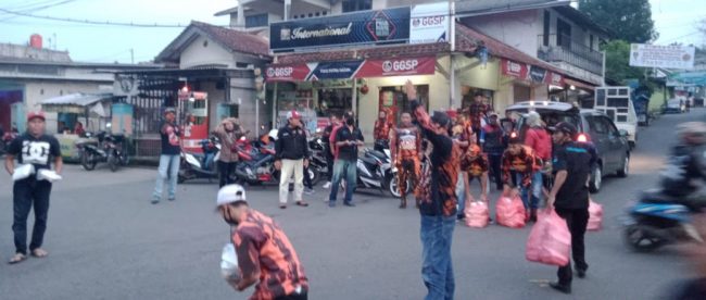 Redaksi Kupas Merdeka dan anggota PAC PP Tamansari membagi-bagikan paket takjil dan nasi box kepada pengguna jalan di Desa Tamansari, Bogor, Sabtu 2/5/2020 (dok. KM)