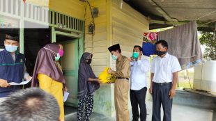 Wakil Bupati Pelalawan Riau, Zardewan didampingi Ketua DPRD Pelalawan Adi Sukemi menyerahkan bantuan kepada warga yang terdampak banjir di Kecamatan Ukui, Selasa 5/5/2020 (dok. KM)
