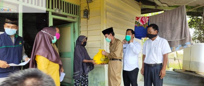 Wakil Bupati Pelalawan Riau, Zardewan didampingi Ketua DPRD Pelalawan Adi Sukemi menyerahkan bantuan kepada warga yang terdampak banjir di Kecamatan Ukui, Selasa 5/5/2020 (dok. KM)