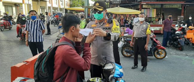 Kapolres Kampar AKBP. Mohammad Kholid memasangkan masker kepada pengendara yang lewat, Sabtu 9/5/2020 (dok. KM)