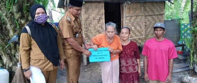 Kepala Desa Sei Dua Hulu, Sumardi Nasution (kedua kiri) didampingi sekretaris desa dan kepala dusun saat menyerahkan BLT DD tahap 2 kepada warga lansia yang kurang mampu di Desa Sei Dua Hulu, Kecamatan Simpang Empat, Kabupaten Asahan, Selasa 16/6/2020 (dok. KM)