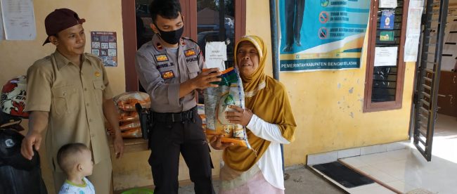 Kapolsek Manna Ipda Davinsi Josie Sidabutar saat menyalurkan bantuan beras kepada masyarakat terdampak covid-19 (dok. KM)